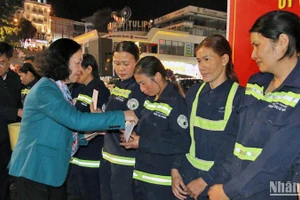 Đồng chí Trương Thị Mai trao quà Tết tặng các lao công đang làm việc trong đêm giao thừa tại thành phố Đà Lạt.