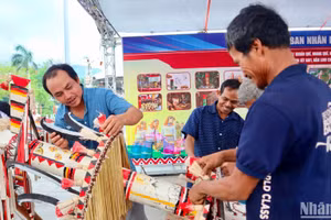 Các nghệ nhân huyện Trà Bồng, tỉnh Quảng Ngãi trang trí, tạo hình cây nêu của người Co. (Ảnh: ĐÔNG HUYỀN)