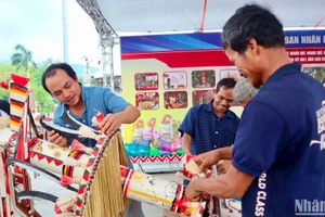 Các nghệ nhân huyện Trà Bồng, tỉnh Quảng Ngãi trang trí, tạo hình cây nêu của người Co. (Ảnh: ĐÔNG HUYỀN)