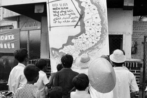 Nhân dân thị xã Phan Thiết (Bình Thuận) vừa được giải phóng theo dõi tin chiến thắng trên bản đồ chiến sự tại phòng thông tin thị xã (tháng 4/1975). (Ảnh: Mai Hưởng/TTXVN)