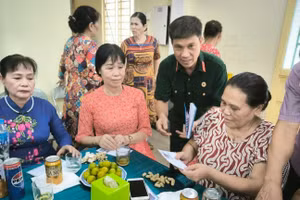 Cựu chiến binh Hoàng Văn Đạt (áo bộ đội) tặng quà các gia đình chính sách phường Đức Giang. 