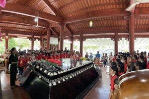 Du khách tham quan, tìm hiểu nhiều hình ảnh tư liệu về Bác Hồ, về quan hệ Việt-Lào được trưng bày tại khuôn viên Khu di tích Kim Liên. (Ảnh: THU THỦY)