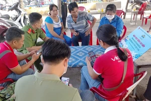 Đồng chí Thông tham gia hỗ trợ người dân thực hiện dịch vụ công trực tuyến.