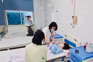Bác sĩ bệnh viện Thanh Nhàn, Hà Nội thăm khám cho trẻ mắc sởi đang điều trị tại khoa Nhi của Bệnh viện. (Ảnh: ĐỖ THOA)