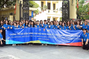 Các liên lạc viên, tình nguyện viên Hội nghị nghị sĩ trẻ toàn cầu lần thứ 9 chụp ảnh lưu niệm trước trụ sở Trung ương Đoàn.