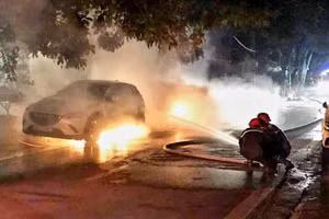 Lực lượng cứu hộ đang dập tắt đám cháy hai xe ô-tô trong đêm, ở thành phố Lào Cai.