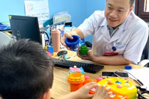 Thạc sĩ, bác sĩ Nguyễn Minh Quyết, Khoa Tâm thần, Bệnh viện Nhi Trung ương khám cho bệnh nhi.