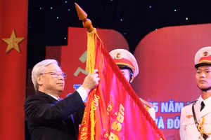 Tổng Bí thư Nguyễn Phú Trọng gắn Huân chương Hồ Chí Minh lần thứ hai lên lá cờ truyền thống của Tạp chí Cộng sản. (Ảnh: Đào Trọng Nguyên)