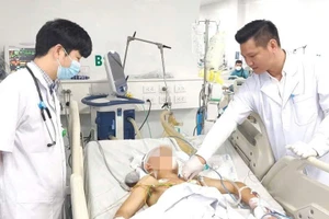 Thạc sĩ, bác sĩ Đồng Phú Khiêm, Phó Giám đốc Trung tâm Hồi sức tích cực, Bệnh viện Bệnh Nhiệt đới Trung ương (trái) thăm khám cho người bệnh.