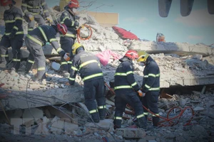 Các thành viên của đội dùng máy cắt chuyên dụng để loại bỏ các đoạn sắt thép xen kẽ trong những mảng bê tông lớn. (Ảnh: Trường Dụy/TTXVN)