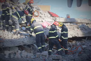 Các thành viên của đội dùng máy cắt chuyên dụng để loại bỏ các đoạn sắt thép xen kẽ trong những mảng bê tông lớn. (Ảnh: Trường Dụy/TTXVN)