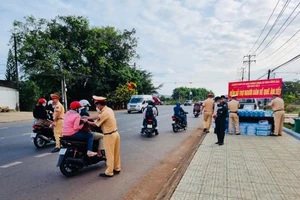 Lực lượng Cảnh sát giao thông Công an tỉnh Đồng Nai phát nước suối, khăn lạnh cho người dân về quê đón Tết trên quốc lộ 20.