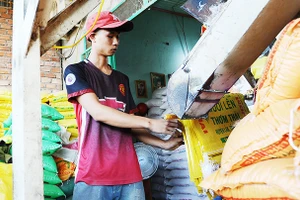 Doanh nghiệp thu mua, đóng bao gạo xuất khẩu. Ảnh: SONG ANH