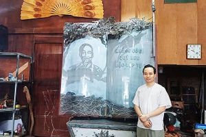 Nghệ nhân Bùi Minh Tự bên tác phẩm “Trang sử vàng”.