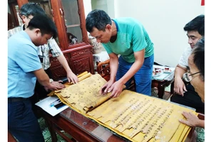 Nhà sưu tập Đặng Vũ Khương cùng đại diện người dân Tri Chỉ kiểm tra tình trạng sắc phong. Ảnh: NCVV