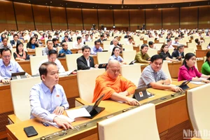 Đại biểu Quốc hội biểu quyết thông qua Nghị quyết thí điểm một số cơ chế, chính sách đặc thù về đầu tư xây dựng công trình giao thông đường bộ. (Ảnh: DUY LINH)