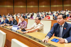 Đại biểu Quốc hội bấm nút thông qua dự thảo Nghị quyết. (Ảnh: DUY LINH)