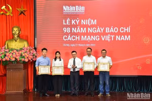 Tổng Biên tập, Bí thư Đảng ủy Báo Nhân Dân Lê Quốc Minh trao Bằng khen tặng các tập thể, cá nhân có thành tích xuất sắc trong năm 2022. (Ảnh: THỦY NGUYÊN)