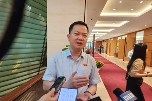 Đại biểu Trịnh Xuân An (đoàn Đồng Nai) trao đổi với phóng viên bên hành lang Quốc hội.