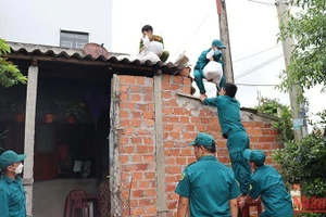 Các lực lượng chức năng giúp người dân thị xã Đức Phổ (Quảng Ngãi) chằng chống nhà cửa ứng phó với bão số 4, tháng 9/2022. (Ảnh: HIỂN CỪ)