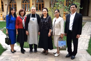 Phu nhân Chủ tịch Quốc hội và các thành viên tháp tùng chụp ảnh kỷ niệm với chủ gia đình cơ sở trưng bày gốm truyền thống Uzbekistan.