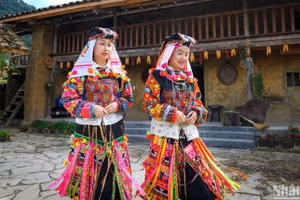 Người Lô Lô Hoa ở chân núi Rồng, thuộc xã Lũng Cú, huyện Đồng Văn, tỉnh Hà Giang bên kiến trúc nhà trình tường lợp ngói đặc trưng. (Ảnh minh họa: THÀNH ĐẠT) 