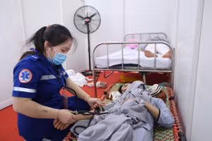 Nhân viên y tế chăm sóc người dân bị say nắng. (Ảnh: THẾ ANH)