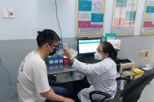 Bác sĩ khám sàng lọc trước tiêm. (Ảnh: Trung tâm Kiểm soát bệnh tật Thành phố Hồ Chí Minh)