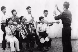 Nhạc sĩ Lan Phong (đứng) chỉ huy anh chị em Đoàn Văn công giải phóng hòa tấu bài nhạc “Giải phóng miền Nam”. Ảnh: Tư liệu 