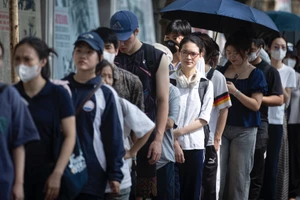 Độc giả xếp hàng để nhận số báo Nhân Dân Cuối tuần đặc biệt về kỷ niệm 135 năm Ngày sinh Chủ tịch Hồ Chí Minh.