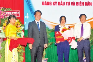 Lãnh đạo tỉnh Vĩnh Long trao giấy chứng nhận cho các nhà đầu tư. (Ảnh BÁ DŨNG)