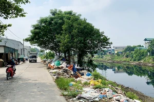 Rác thải của làng nghề làm chăn, ga, gối, đệm Trát Cầu (huyện Thường Tín, Hà Nội) đổ ra bờ sông Nhuệ.