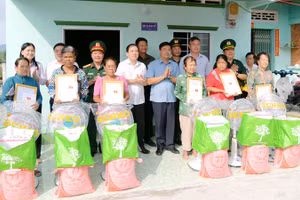 Bí thư Tỉnh ủy Kiên Giang Nguyễn Tiến Hải (thứ 5, từ trái qua) bàn giao nhà “Đại đoàn kết” và tặng quà cho người dân. (Ảnh: PHƯƠNG VŨ)