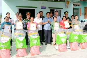 Bí thư Tỉnh ủy Kiên Giang Nguyễn Tiến Hải (thứ 5, từ trái qua) bàn giao nhà “Đại đoàn kết” và tặng quà cho người dân. (Ảnh: PHƯƠNG VŨ)