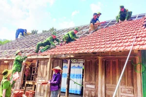 Đoàn viên Bộ đội Biên phòng và Công an tỉnh Quảng Bình tham gia sửa chữa nhà tạm cho hộ nghèo ở xã Thượng Hóa, huyện Minh Hóa.