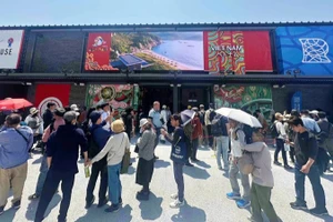 Khách tham quan xếp hàng vào thăm Nhà triển lãm Việt Nam tại EXPO 2025. 