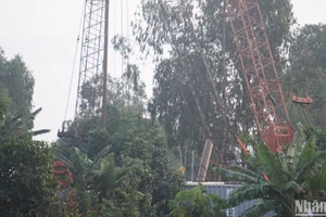 Cẩu một phần trụ bê-tông tại hiện trường chiều 19/1.