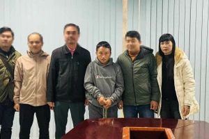 Thượng tá Nguyễn Thị Hồng Thúy (ngoài cùng bên phải) tiếp nhận đối tượng đặc biệt nguy hiểm từ công an nước bạn Lào. (Ảnh: NVCC)