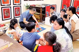 Nghệ nhân Ðào Ðình Chung giới thiệu kỹ thuật làm tranh cho các bạn nhỏ.