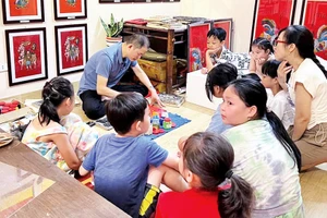 Nghệ nhân Ðào Ðình Chung giới thiệu kỹ thuật làm tranh cho các bạn nhỏ.