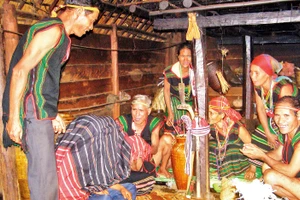 Già làng và bà mối trùm chăn cho đôi vợ chồng trẻ, một nghi thức trong lễ cưới của người M’nông.