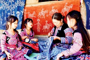 Người dân tộc H’Mông ở xã Pà Cò truyền nghề dệt thổ cẩm cho thế hệ trẻ. 