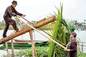 Nghệ nhân làng mộc Kim Bồng trình diễn nghi thức lấy gỗ làm mộc. 