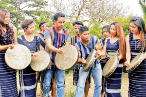 Những chàng trai Cơ Ho dạy sơn nữ đánh chiêng.