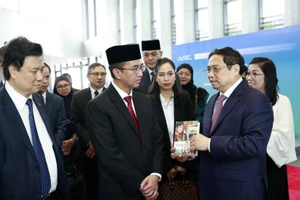 Thủ tướng Phạm Minh Chính xem trưng bày sách tiếng Việt tại Trường đại học Quốc gia Brunei. (Ảnh TTXVN)