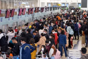 Hành khách làm thủ tục hàng không tại Nhà ga T1 Cảng hàng không quốc tế Nội Bài giờ cao điểm sáng 29/1. 