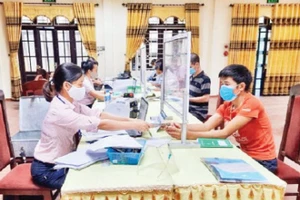 Ngân hàng Chính sách xã hội giải ngân vốn vay cho hộ nghèo tại thị trấn Tây Đằng. (Ảnh KIM DUNG)