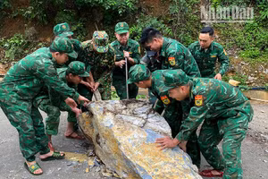 Cán bộ, chiến sĩ Đồn Biên phòng Chiềng Tương, Bộ đội Biên phòng tỉnh Sơn La khắc phục tuyến đường bị đá sạt lở chắn ngang.