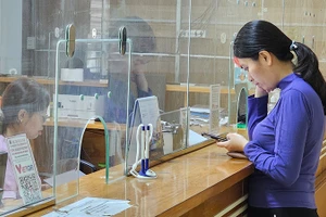 Người dân làm thủ tục đăng ký khám, chữa bệnh tại cơ sở y tế công lập.