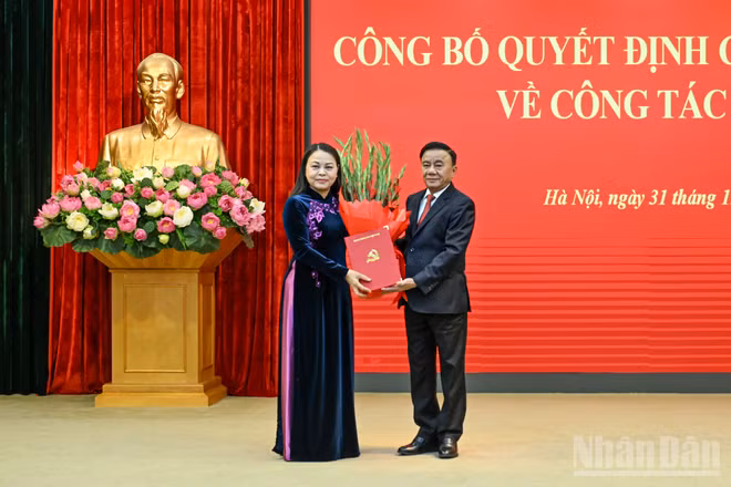 Thường trực Ban Bí thư Trần Cẩm Tú trao Quyết định của Bộ Chính trị, tặng hoa chúc mừng đồng chí Nguyễn Thị Thu Hà. (Ảnh: DUY LINH)